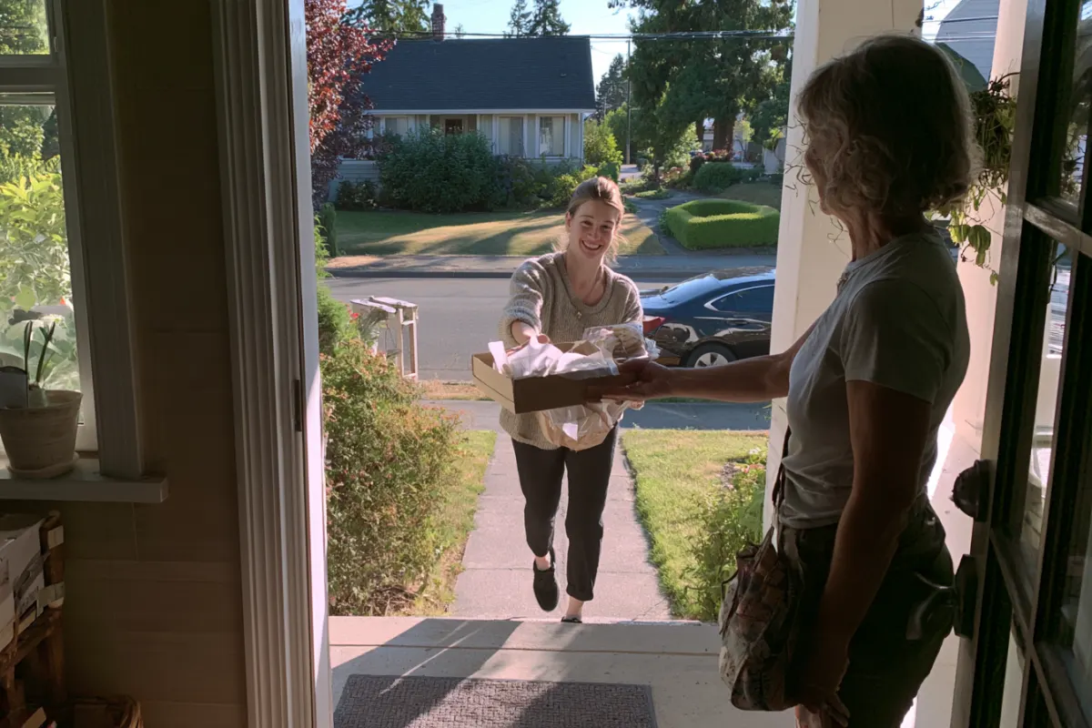 A customer picking up a cake at the door